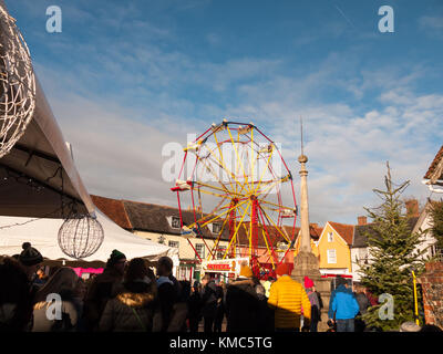 Carrousel rouge et jaune à l'extérieur de la roue avec les personnes ci-dessous ciel bleu de Noël ; Essex ; Angleterre ; uk Banque D'Images