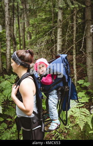 Mère transportant son bébé dans un sac à dos Banque D'Images