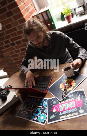 Graphiste masculin travaillant sur un ordinateur portable Banque D'Images