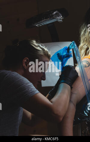 L'artiste tattoo professionnel fait un tatouage à la main des womans Banque D'Images
