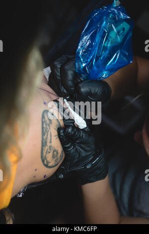 L'artiste tattoo professionnel fait un tatouage à la main des womans Banque D'Images
