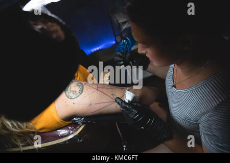 L'artiste tattoo professionnel fait un tatouage à la main des womans Banque D'Images