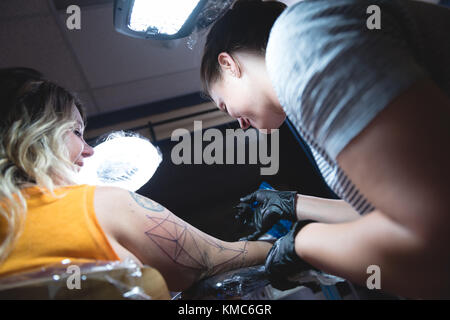 L'artiste tattoo professionnel fait un tatouage à la main des womans Banque D'Images