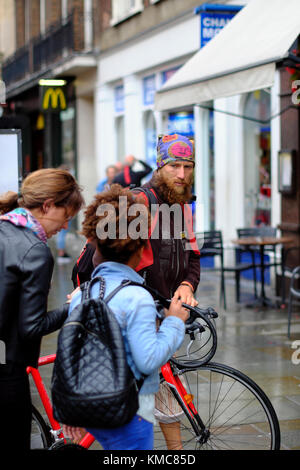 Cycliste barbu portant bandana en poussant son vélo sur le trottoir à Londres, Angleterre, RU Banque D'Images