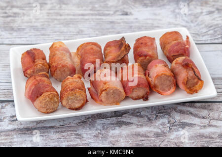 Les porcs dans des couvertures - saucisses de porc enrobé de bacon Banque D'Images