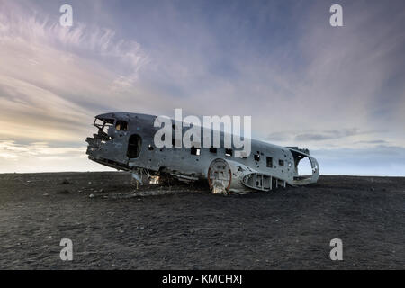 Un paysage extraordinaire avec avion DC-3 s'est écrasé sur la plage au coucher du soleil. solheimasandur épave de l'avion sur la plage de sable noir dans le sud de l'Islande. Banque D'Images