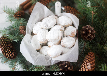 Mini stollen stollen ou des bonbons dans une boîte en fer sur fond de branches de sapin et les cônes. Banque D'Images