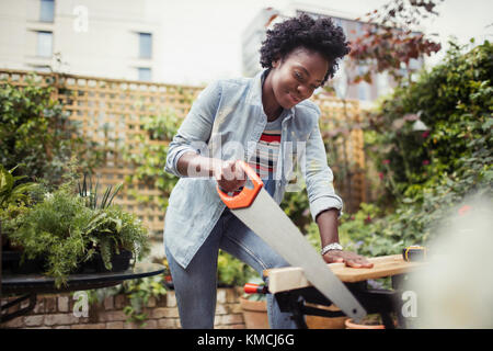 Femme avec scie de coupe de bois Banque D'Images