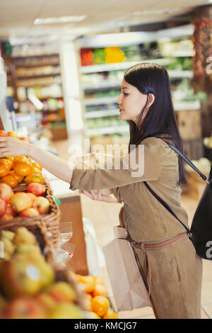 Jeune femme magasiner pour des produits à l'épicerie Banque D'Images