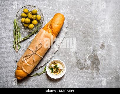 Le ciabatta enveloppé dans du papier avec le romarin et l'huile. sur la table en pierre. l'espace libre pour le texte . Vue du dessus Banque D'Images