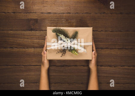 Man holding Christmas presents posés sur une table en bois. Joyeux Noël carte de vœux. Espace libre Banque D'Images