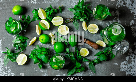 Mojito cocktail . une grande table avec des ingrédients pour faire des mojitos - citron vert, feuilles de menthe, rhum, sucre et d'agrumes couteau. la table de pierre . Vue du dessus Banque D'Images