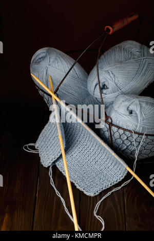 Le tricot de fil bleu clair sur fond en bois brun foncé. Banque D'Images