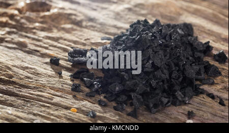 Tas de sel de lave noire sur table en bois. Vue rapprochée. Banque D'Images