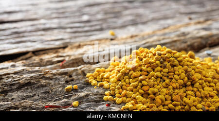 Bee pollen pile situé sur la surface en bois. Vue rapprochée et de l'espace pour le texte. Banque D'Images