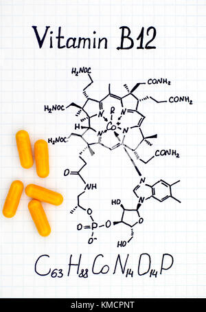 Formule chimique de la vitamine B12 et le jaune des pilules. Close-up. Banque D'Images