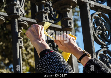 Barcelone, Catalogne, espagne. 6e dec 2017. Les mains liées d'un ruban jaune à la porte du parc de la Ciutadella.L'appui au mouvement indépendantiste sont continues en Catalogne.ce matin, organisée par plusieurs comités de la république catalane, la défense d'un groupe de personnes a décoré la façade principale du parc de la Ciutadella à Barcelone avec de nombreux liens. jaune le ruban jaune a été interdit par le conseil électoral espagnol qui contrôle la campagne électorale en Catalogne. l'action d'aujourd'hui est la partie de la revendication d'une constitution catalane, bien que le ruban jaune a beco Banque D'Images