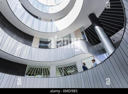 Les hommes d'affaires parlent sur le balcon de l'atrium de bureau moderne et architectural Banque D'Images