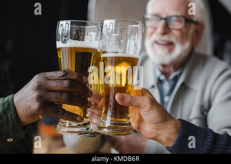 Friends clinking verres de bière Banque D'Images