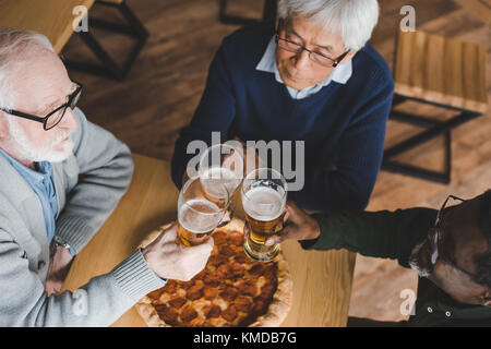 Senior friends clinking verres de bière Banque D'Images