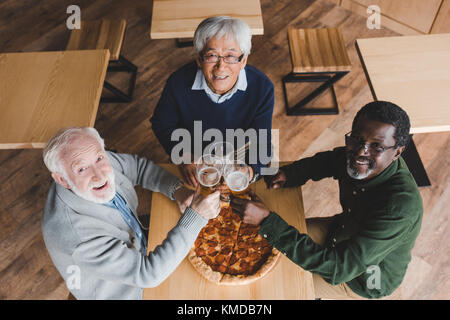 Senior friends clinking verres de bière Banque D'Images