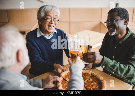 Senior friends clinking verres de bière Banque D'Images