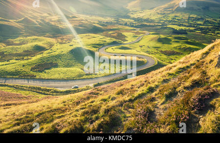 Scenic Route serpentine au coucher du soleil chaud de l'été. à la lumière des avis de pistes en heather de mam tor Banque D'Images