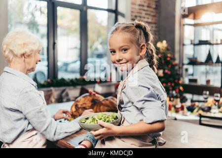 Petite-fille d'aider pour grand-mère sur la cuisine Banque D'Images