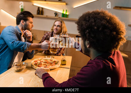 Les amis de pizza et de la bière en bar Banque D'Images