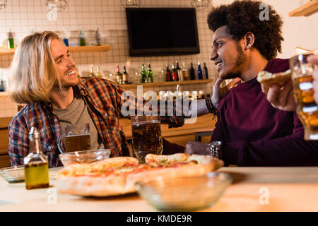 Les amis de boire une bière en bar Banque D'Images