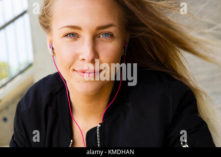 Fermer portrait de femme blonde dans les vêtements de sport écouter de la musique Banque D'Images