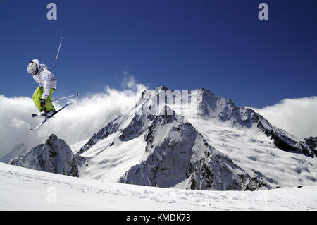 Saut à ski skis croisés dans des hautes montagnes de neige au soleil Journée d'hiver. Ski acrobatique. Banque D'Images