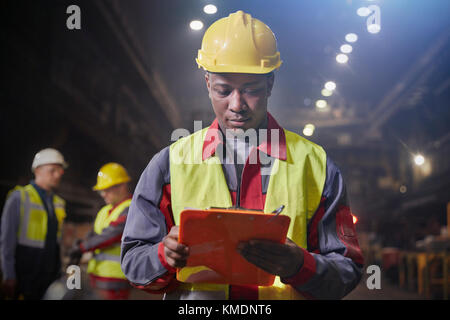 Presse-papiers avec le métallo travaillant dans Steel mill Banque D'Images