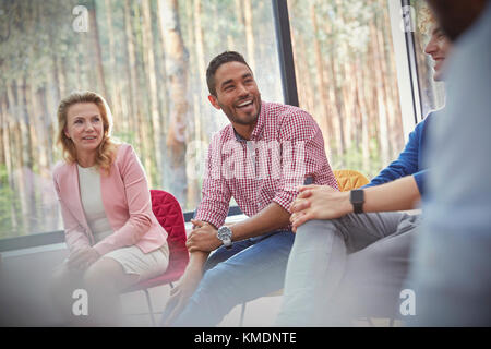 Homme souriant écoutant la séance de thérapie de groupe Banque D'Images