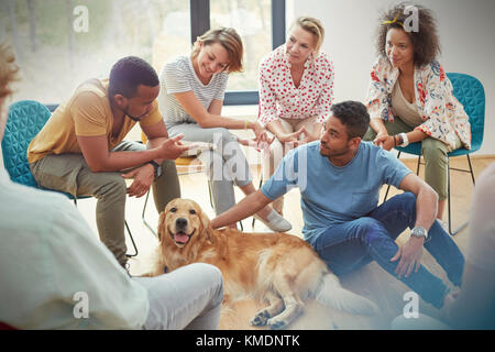 Les personnes qui dressent le chien en séance de thérapie de groupe Banque D'Images