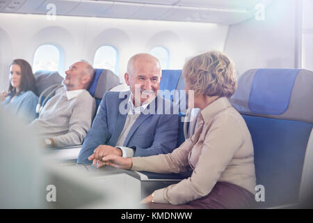 Couple affectueux et mature tenant les mains sur l'avion Banque D'Images