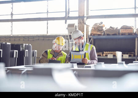 Réunion des Steelworkers avec ordinateur portable dans l'aciérie Banque D'Images