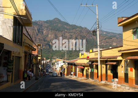 Tepoztlán, Morelos, Mexique - 2017 : la rue principale, avec des maisons traditionnelles peintes en jaune et rouge, et la montagne d'el tepozteco dans l'arrière-plan Banque D'Images