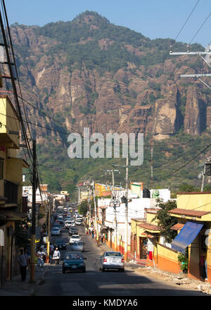 Tepoztlán, Morelos, Mexique - 2017 : la rue principale, avec des maisons traditionnelles peintes en jaune et rouge, et la montagne d'el tepozteco dans l'arrière-plan Banque D'Images