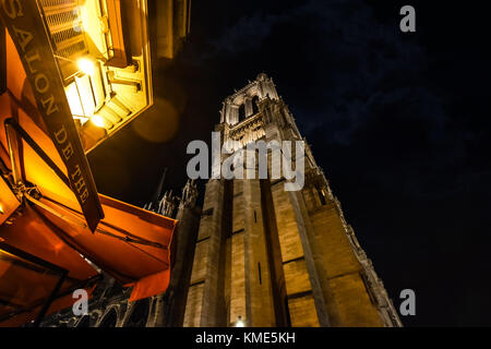 Jusqu'à au clocher de la cathédrale Notre Dame sur l'Île de la Cité à Paris France tout en dînant tard en soirée à un sidewalk cafe Banque D'Images