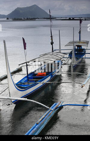 Amarré à l'embarcadère des bateaux de la pompe dans le lac Taal sous forte pluie attendre aux touristes d'effectuer à l'intérieur de l'île volcan Taal volcano-binintiang malaki ou grand arc de jambe Banque D'Images