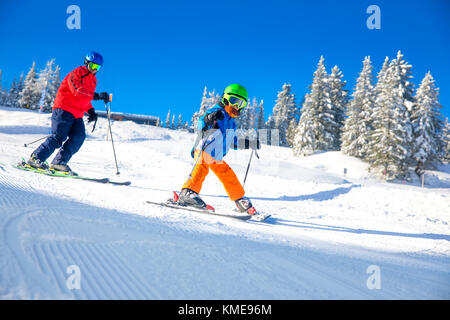 Heureux petit garçon avec son père sur le ski ski dans les Alpes. Banque D'Images