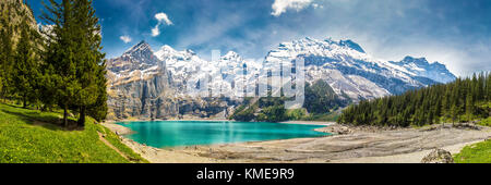 Une tourquise Oeschinnensee avec chutes d'eau, chalet en bois et des Alpes suisses, Berner Oberland, Suisse. Banque D'Images