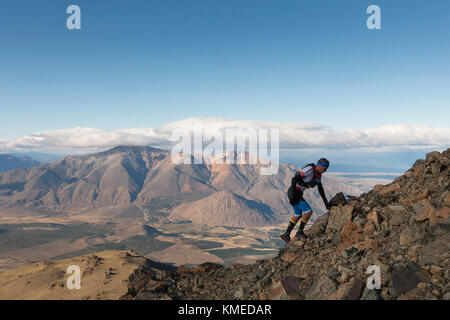 Rocky Mountain escalade homme contre les nuages et ciel, Esquel, Chubut, Argentine Banque D'Images