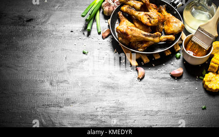 Cuisses de poulet frit avec des morceaux de maïs et la sauce tomate. Banque D'Images