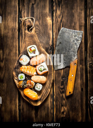 Des sushis et rouleaux avec le saumon et l'ancienne ax. sur fond de bois. Banque D'Images