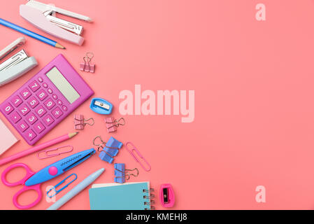 Concept stationnaire, télévision jeter dessus voir photo de ciseaux, crayons, trombones,calculator,sticky note,agrafeuse et le bloc-notes de rose et ton bleu sur Rose Banque D'Images