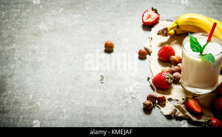 Dessert avec du lait de noix, de baies et de bananes. sur la table de pierre. Banque D'Images