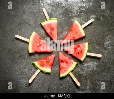 Tranches de melon sur des bâtonnets de bois. sur la table de pierre. Banque D'Images