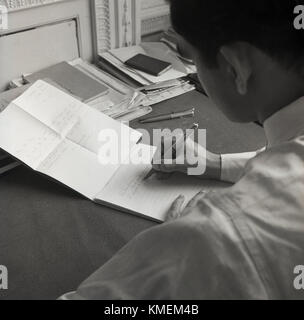 Années 1950, historique, la correspondance écrite, un homme écrit une lettre de remerciement avec un stylo en réponse à une invitation par lettre, Londres, Angleterre, Banque D'Images